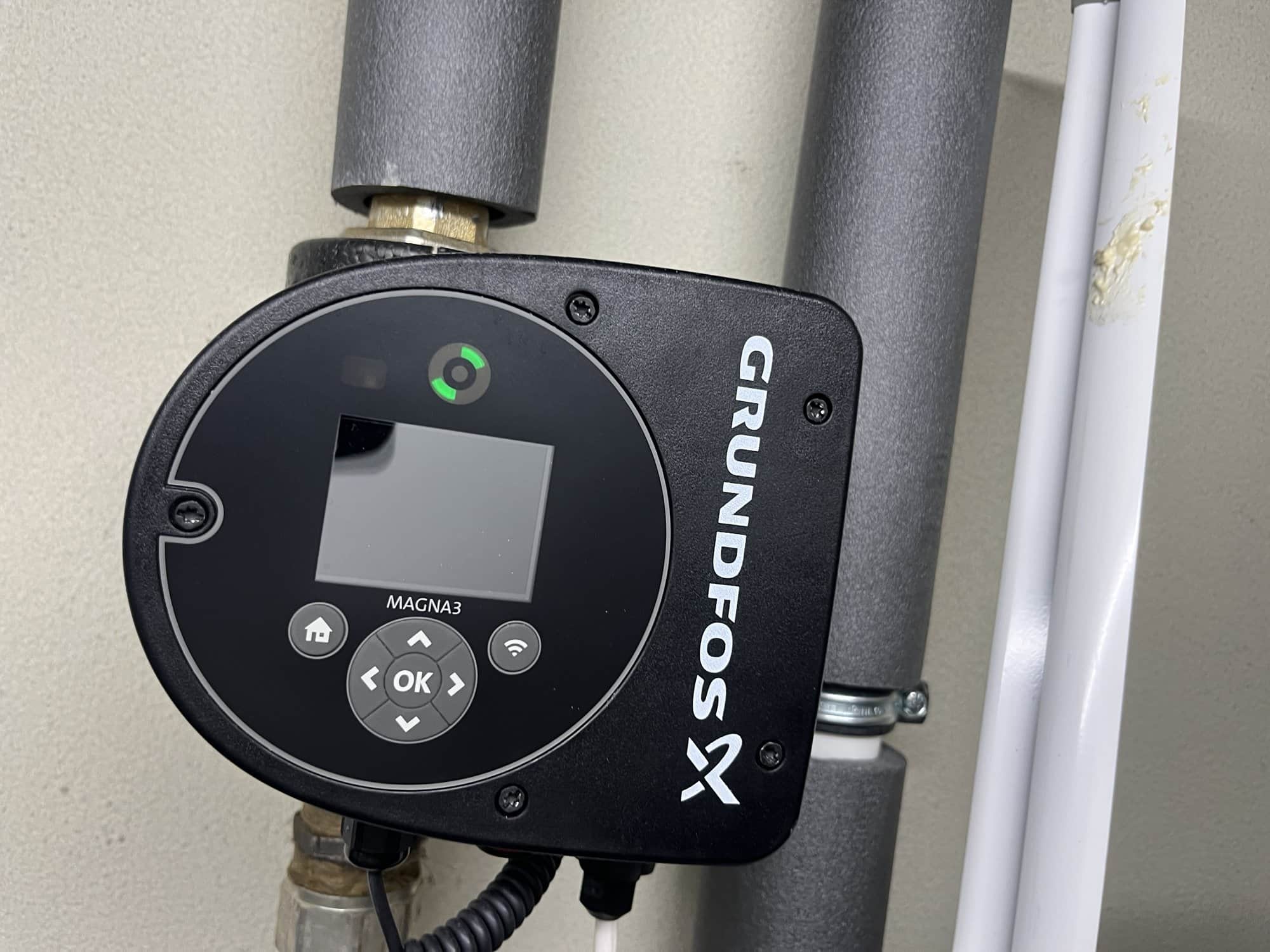 Elektronisch geregelde circulatiepomp met display op geisoleerde leidingen.