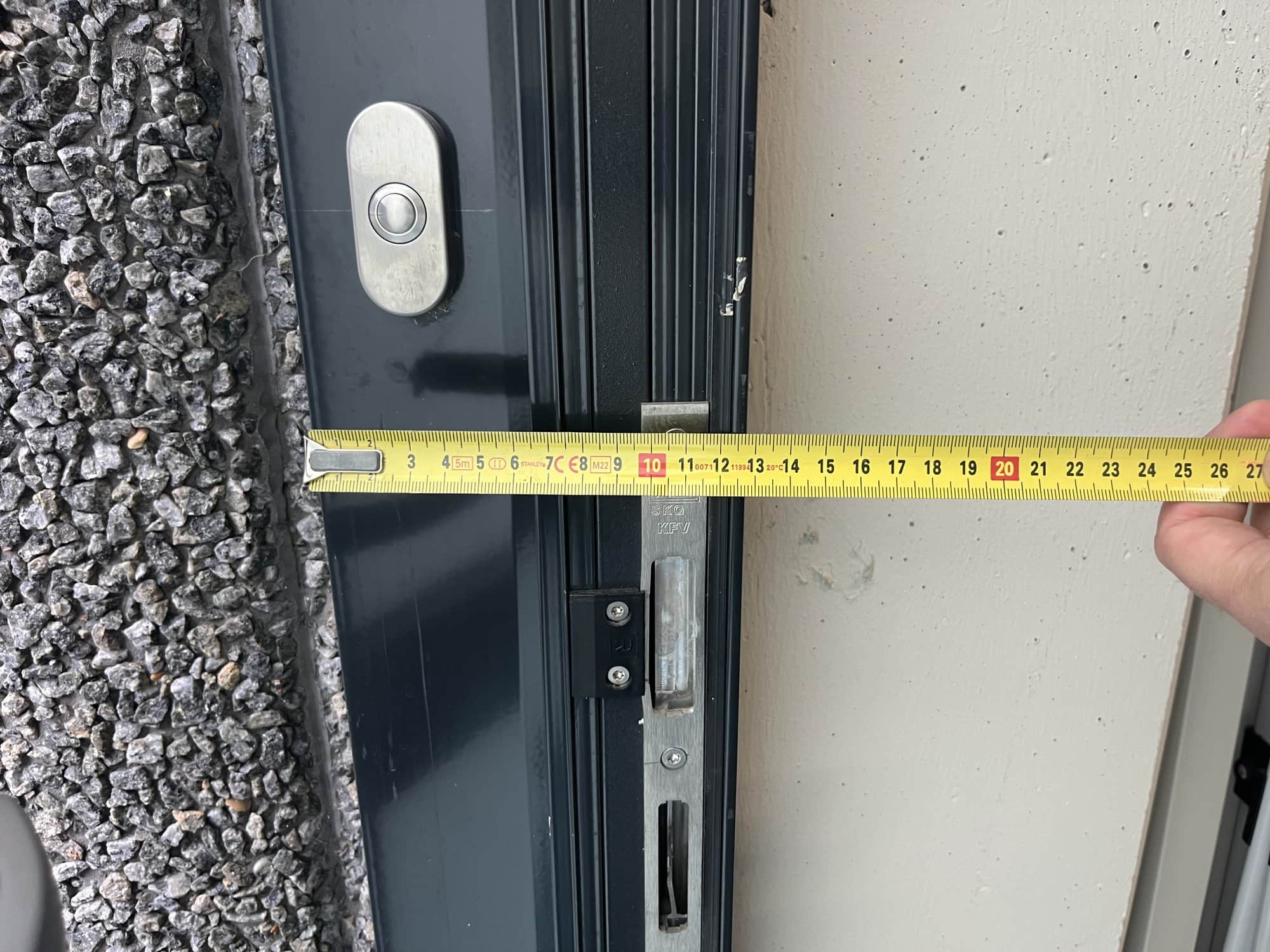 Rolmaat tegen een deurkozijn tijdens het inmeten voor toegangscontrole.