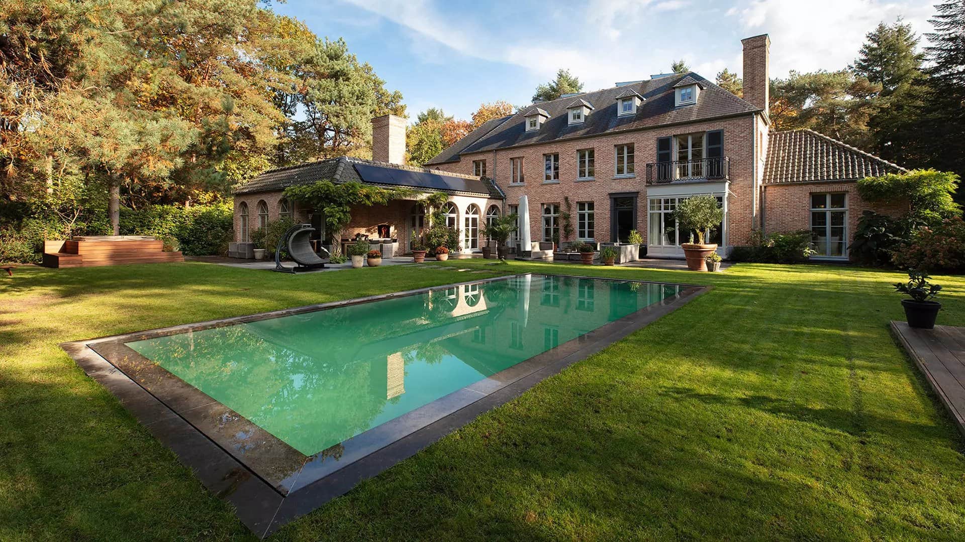 Villa met buitenzwembad in een grote tuin.