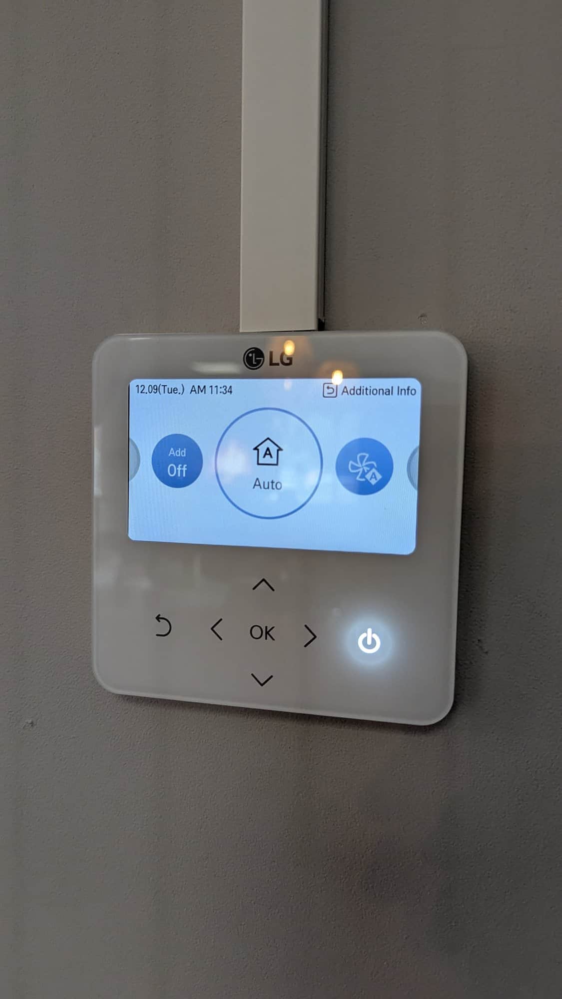 Touchbediening van de warmtepomp op een donkere wand.